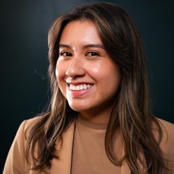 Nancy Garcia smiles wearing a brown blazer and shirt